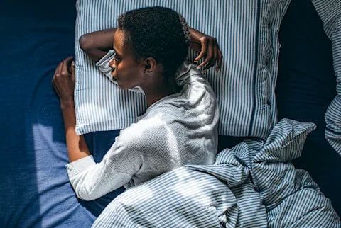 Overhead photo of a woman sleeping with her arm under her head Overhead photo of a woman sleeping with her arm under her head